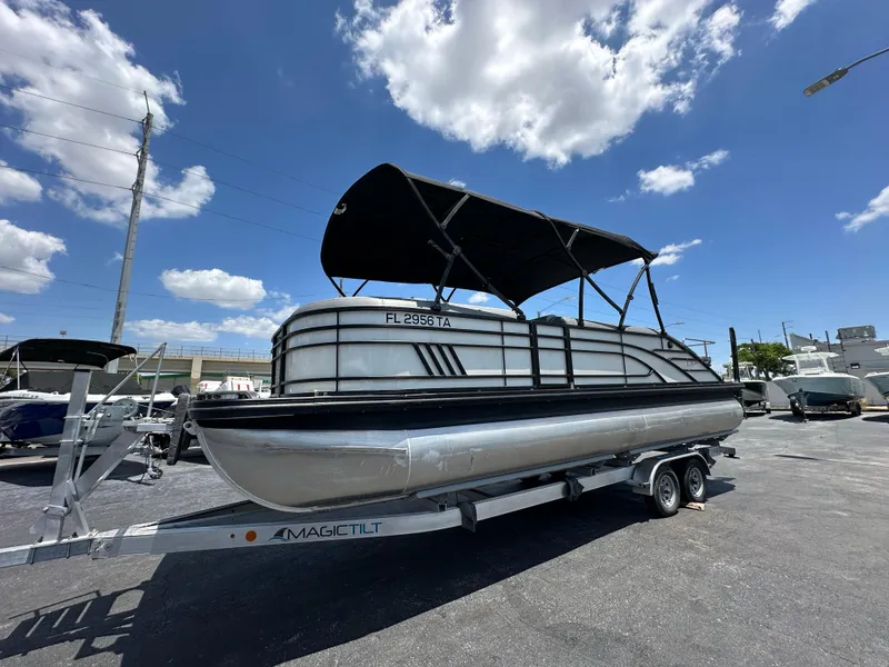 Slide: The Image of 2021 Bennington LX 24 Stern Lounge pontoon boat on trailer under blue sky. - 5