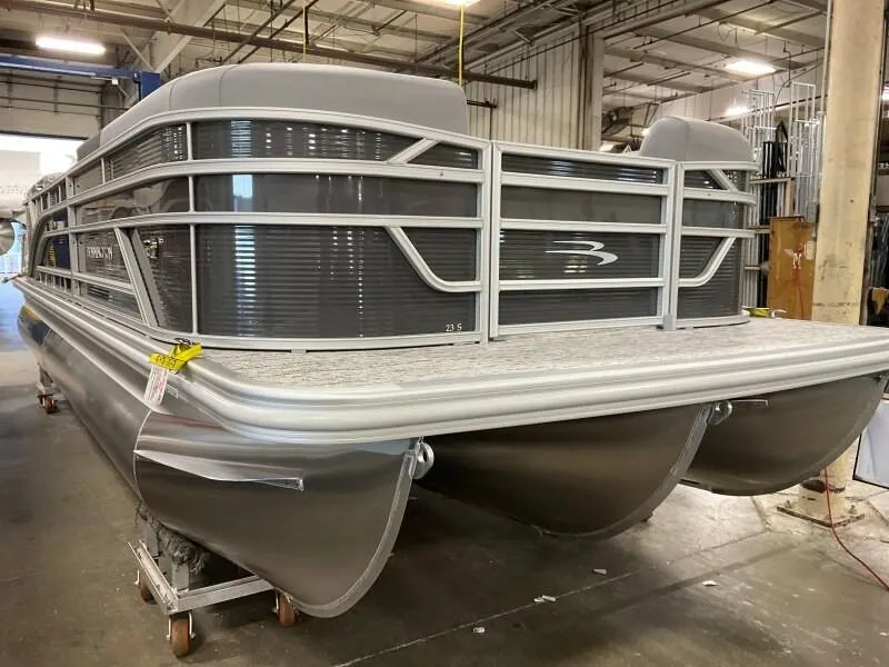 Slide: The Image of 2025 Bennington 23SSR-SPS pontoon boat in a warehouse setting. - 1