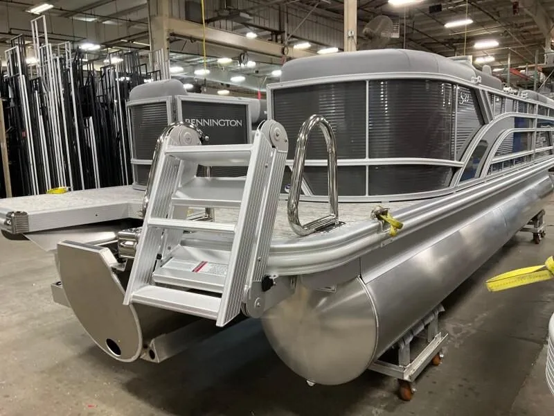 Slide: The Image of 2025 Bennington 23SSR-SPS pontoon boat in a factory setting, showcasing sleek design. - 14