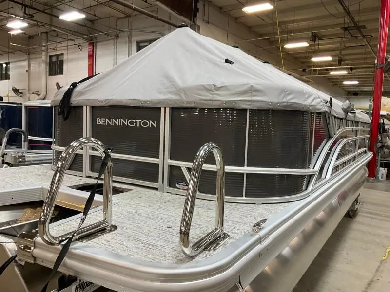 Slide: The Image of 2025 Bennington 23SSR-SPS pontoon boat with cover in a warehouse setting. - 15