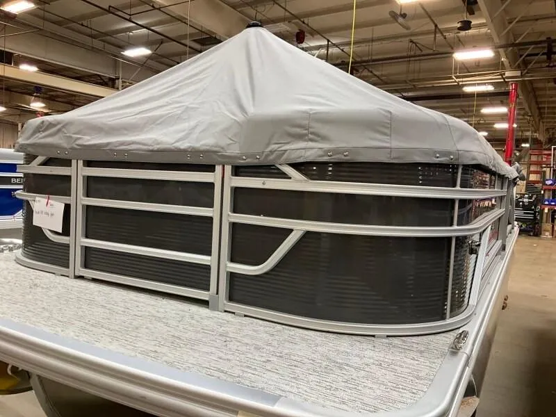 Slide: The Image of 2025 Bennington 23SSR-SPS (PB) pontoon boat with cover in a warehouse setting. - 3