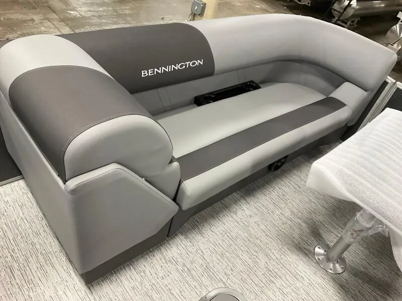 Slide: The Image of 2025 Bennington 23SSR-SPS (PB) boat seating, gray and black upholstery, indoor setting. - 6