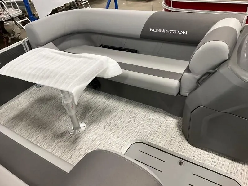 Slide: The Image of 2025 Bennington 23SSR-SPS (PB) boat interior with gray seating and covered table. - 7