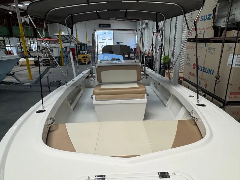 Slide: The Image of 2019 Parker 1801 CC boat interior with seating, under a canopy, in a warehouse setting. - 4