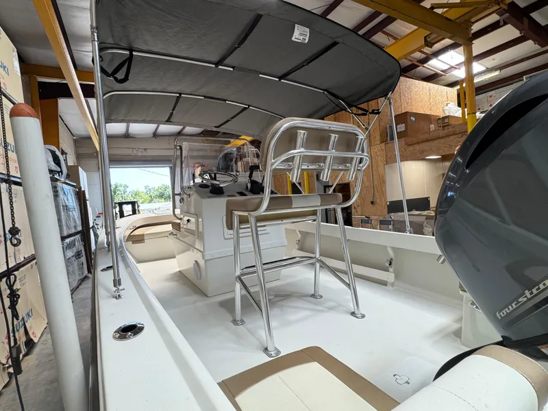 Slide: The Image of 2019 Parker 1801 CC boat in a workshop, featuring a canopy and seating. - 6