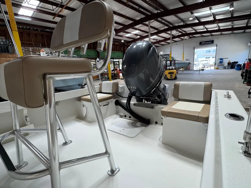 Slide: The Image of 2019 Parker 1801 CC boat interior with seating and outboard motor in a warehouse. - 7