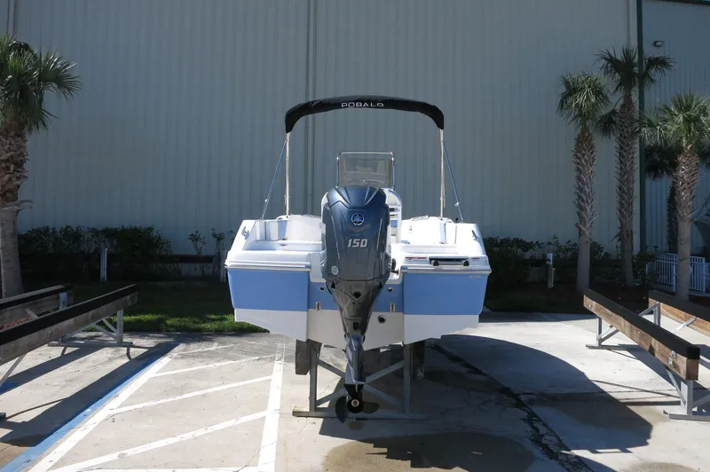 Slide: The Image of 2025 Robalo R180 Center Console boat with Yamaha 150 engine, parked outdoors. - 16