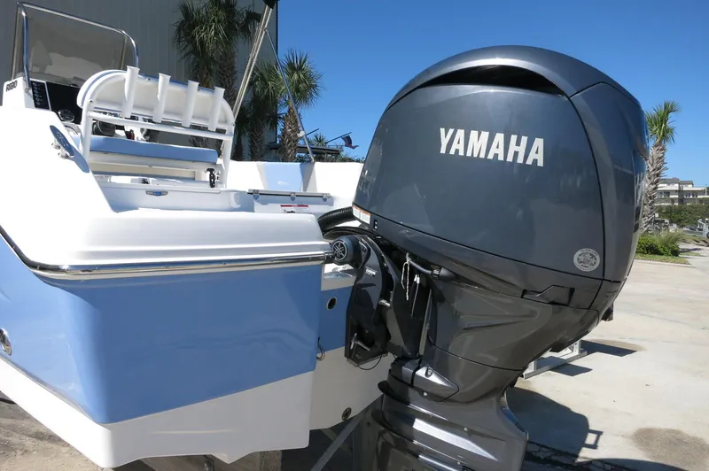 Slide: The Image of 2025 Robalo R180 Center Console boat with Yamaha outboard motor, docked outdoors. - 17