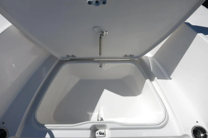 Slide: The Image of 2025 Robalo R180 Center Console storage compartment, open lid, white interior. - 22