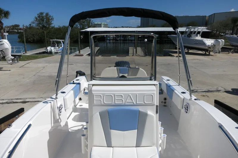Slide: The Image of 2025 Robalo R180 Center Console boat at dock, featuring sleek design and spacious seating. - 24