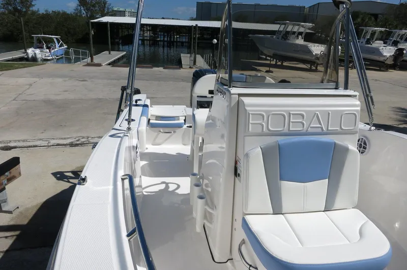 Slide: The Image of 2025 Robalo R180 Center Console boat, docked, showcasing sleek design and seating. - 25