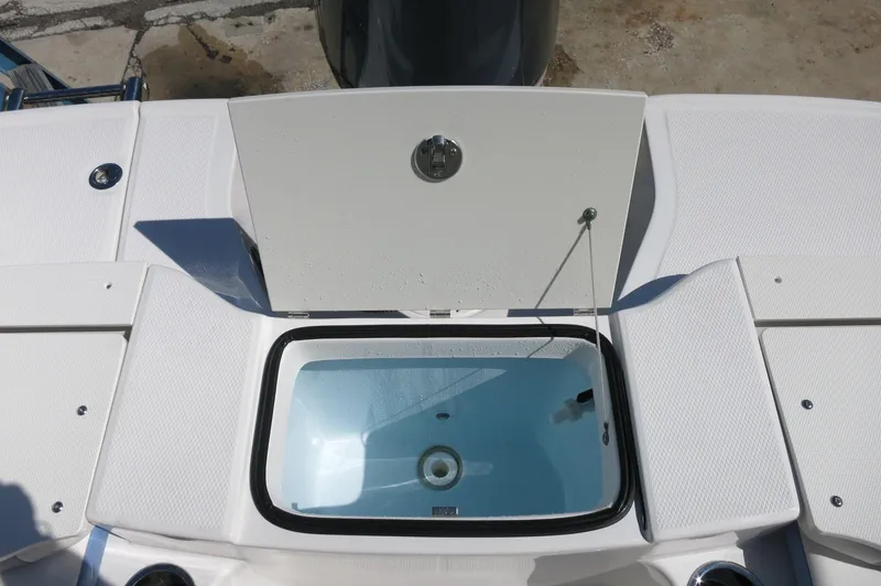 Slide: The Image of 2025 Robalo R180 Center Console livewell with open lid, showcasing interior details. - 32