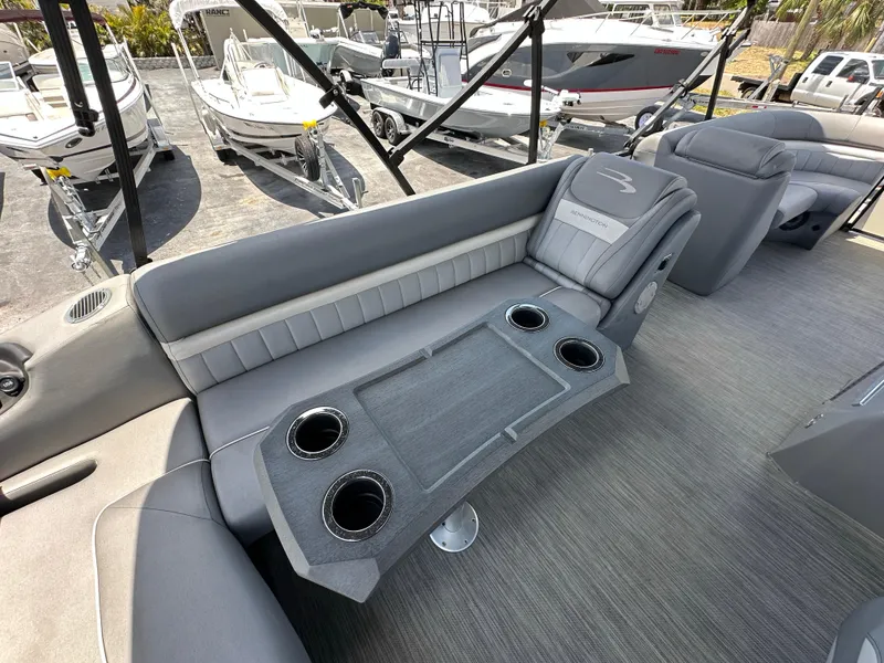 Slide: The Image of 2021 Bennington LX 24 Swingback boat interior with gray seating and cup holders. - 10