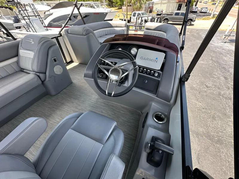 Slide: The Image of 2021 Bennington LX 24 Swingback boat interior with Garmin navigation system and plush seating. - 16