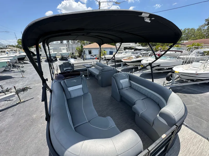 Slide: The Image of 2021 Bennington LX 24 Swingback pontoon boat with spacious seating and canopy, docked under blue sky. - 21