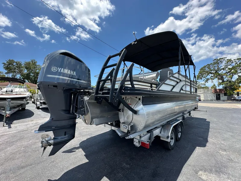 Slide: The Image of 2021 Bennington LX 24 Swingback pontoon boat with Yamaha outboard motor on a trailer. - 4