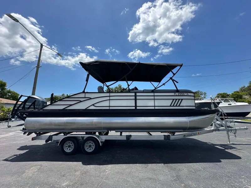 Slide: The Image of 2021 Bennington LX 24 Swingback pontoon boat on trailer under clear sky. - 5