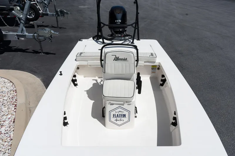 Slide: The Image of 2023 Maverick 18 HPX-V boat interior with seating and motor, parked on pavement. - 18