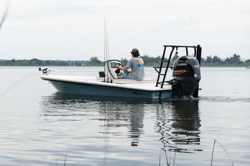 Slide: The Image of 2023 Maverick 18 HPX-V boat on calm water with a person steering. - 2