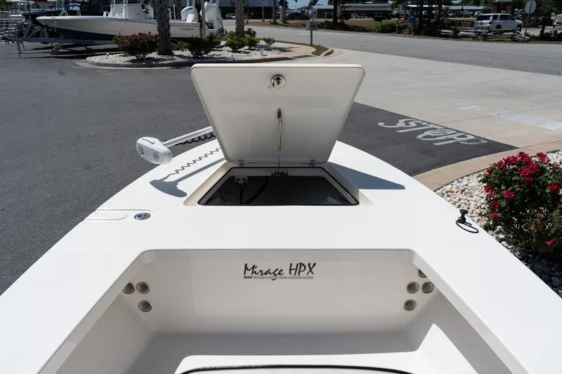 Slide: The Image of 2023 Maverick 18 HPX-V boat with open storage compartment, docked outdoors. - 22