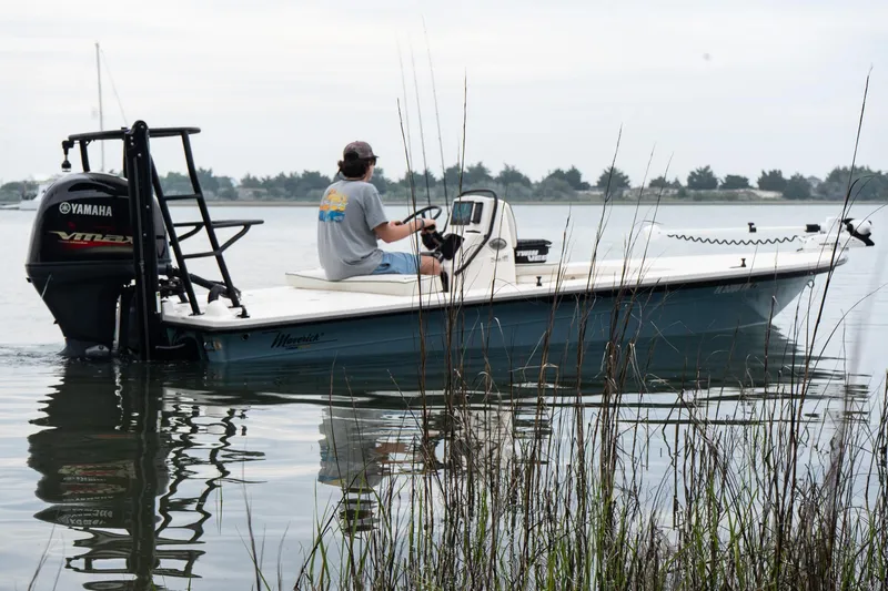 Slide: The Image of 2023 Maverick 18 HPX-V boat on calm water with Yamaha engine, person steering. - 6