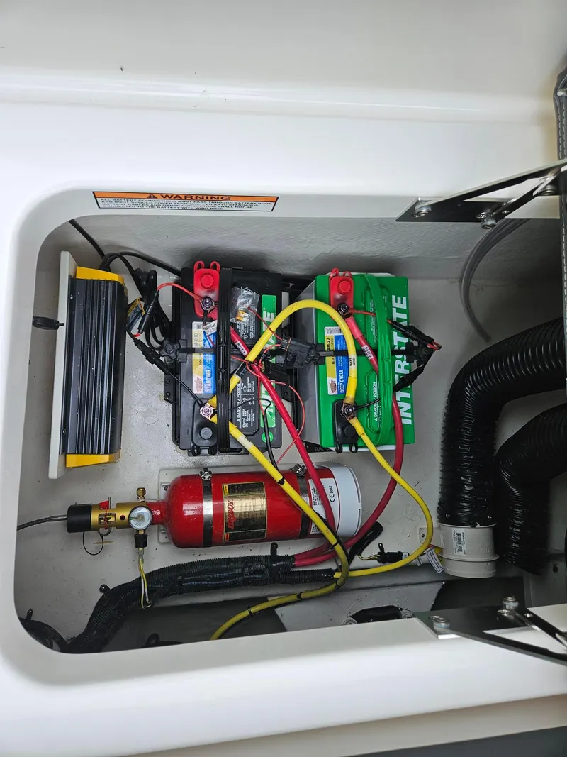 Slide: The Image of 2025 Chaparral 247 SSX boat battery compartment with wiring and fire extinguisher. - 35