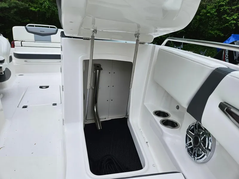 Slide: The Image of 2025 Chaparral 247 SSX boat interior with storage compartment and cup holders. - 49