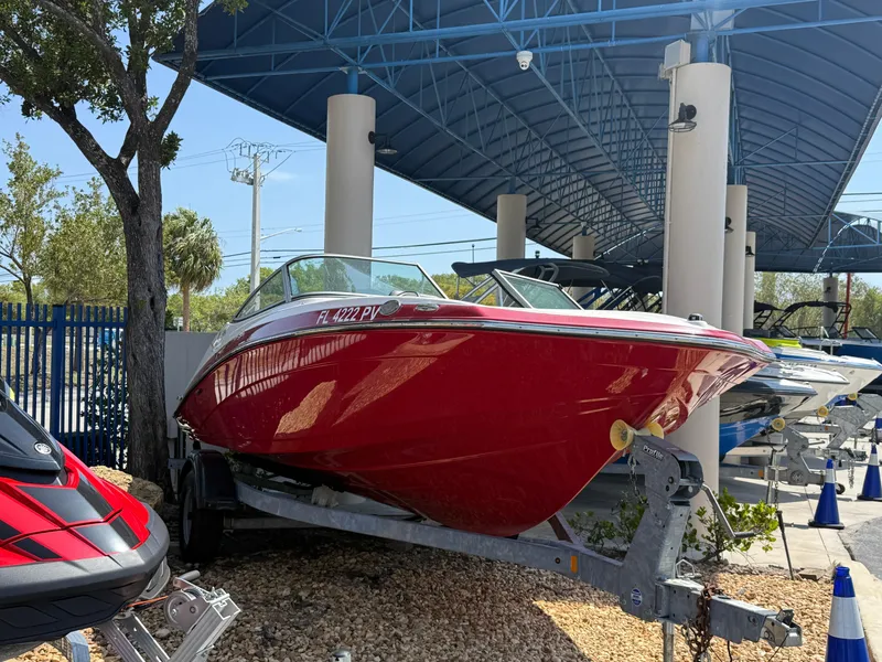 Slide: The Image of 2015 Yamaha Boats SX192 in red, displayed on a trailer under a canopy. - 3