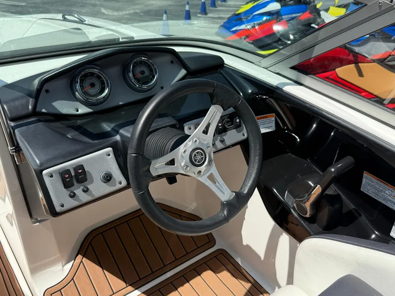 Slide: The Image of 2015 Yamaha Boats SX192 dashboard and steering wheel, featuring modern controls and wood-style flooring. - 6