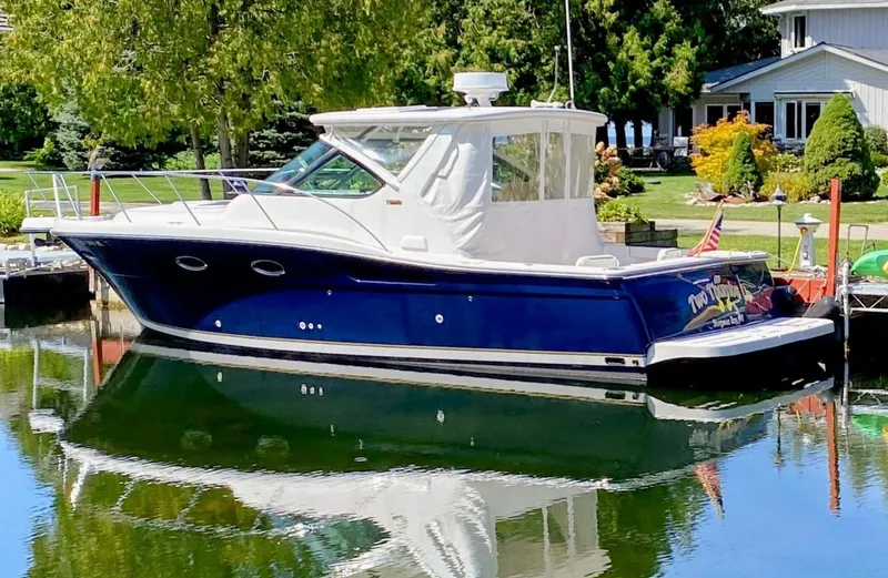 Slide: The Image of 2005 Tiara Yachts 32 Open boat docked on a calm, reflective waterway. - 0