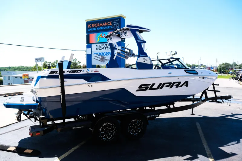 Slide: The Image of 2023 Supra SL boat on trailer at dealership, showcasing sleek design and modern features. - 6