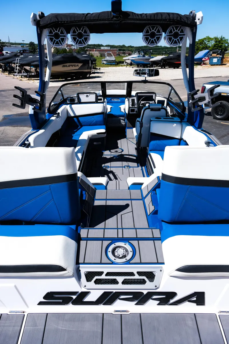 Slide: The Image of 2023 Supra SL boat interior with blue and white seating, advanced sound system, and sleek design. - 8