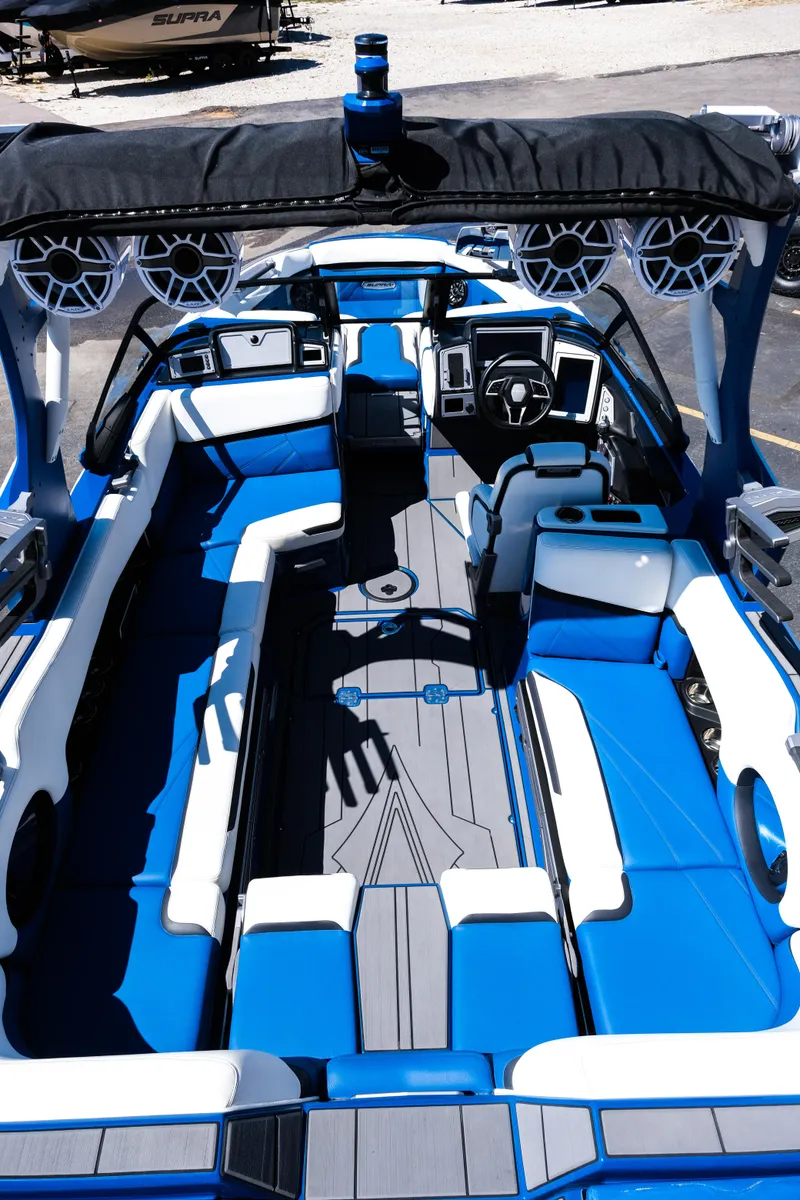 Slide: The Image of 2023 Supra SL boat interior with blue and white seating, advanced dashboard, and spacious layout. - 9