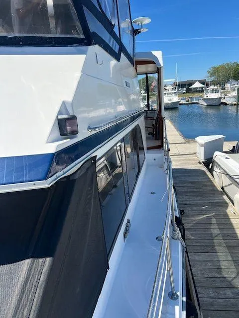 Slide: The Image of 1990 Jefferson 42 Viscount Sundeck yacht docked at a marina, side view. - 11