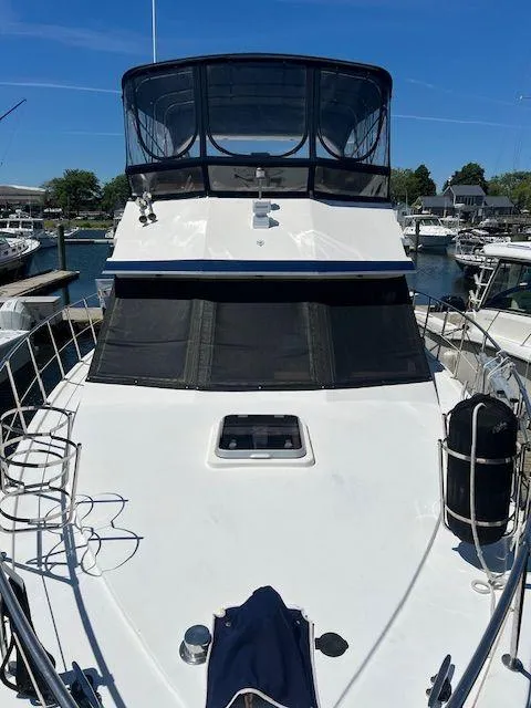 Slide: The Image of 1990 Jefferson 42 Viscount Sundeck yacht docked at marina under clear blue sky. - 14