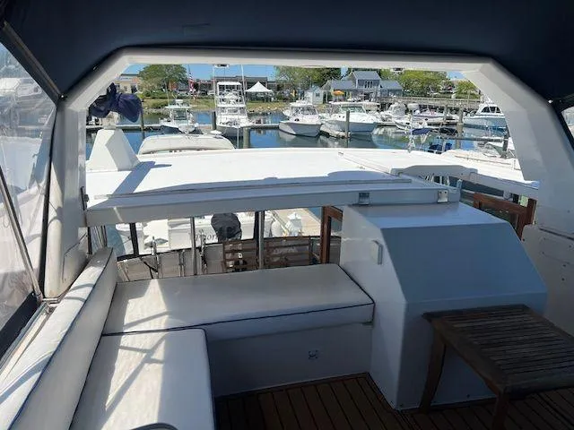 Slide: The Image of 1990 Jefferson 42 Viscount Sundeck yacht interior with marina view, featuring seating and wooden table. - 29