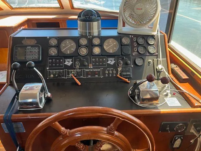 Slide: The Image of 1990 Jefferson 42 Viscount Sundeck helm with gauges, controls, and wooden steering wheel. - 35