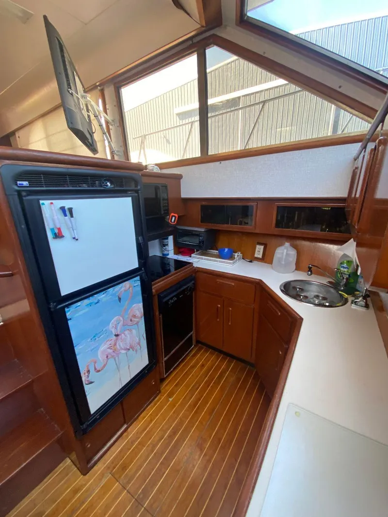 Slide: The Image of 1990 Jefferson 42 Viscount Sundeck yacht kitchen with wood cabinetry and modern appliances. - 38
