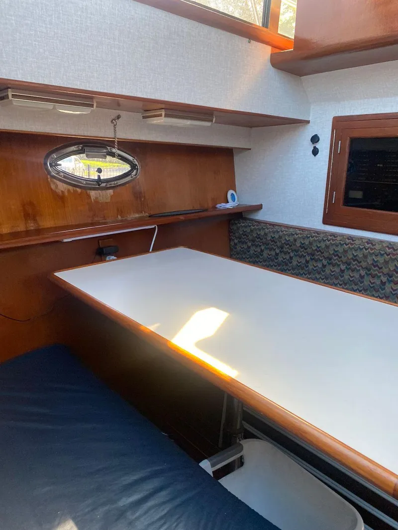 Slide: The Image of 1990 Jefferson 42 Viscount Sundeck interior with table, seating, and porthole window. - 40