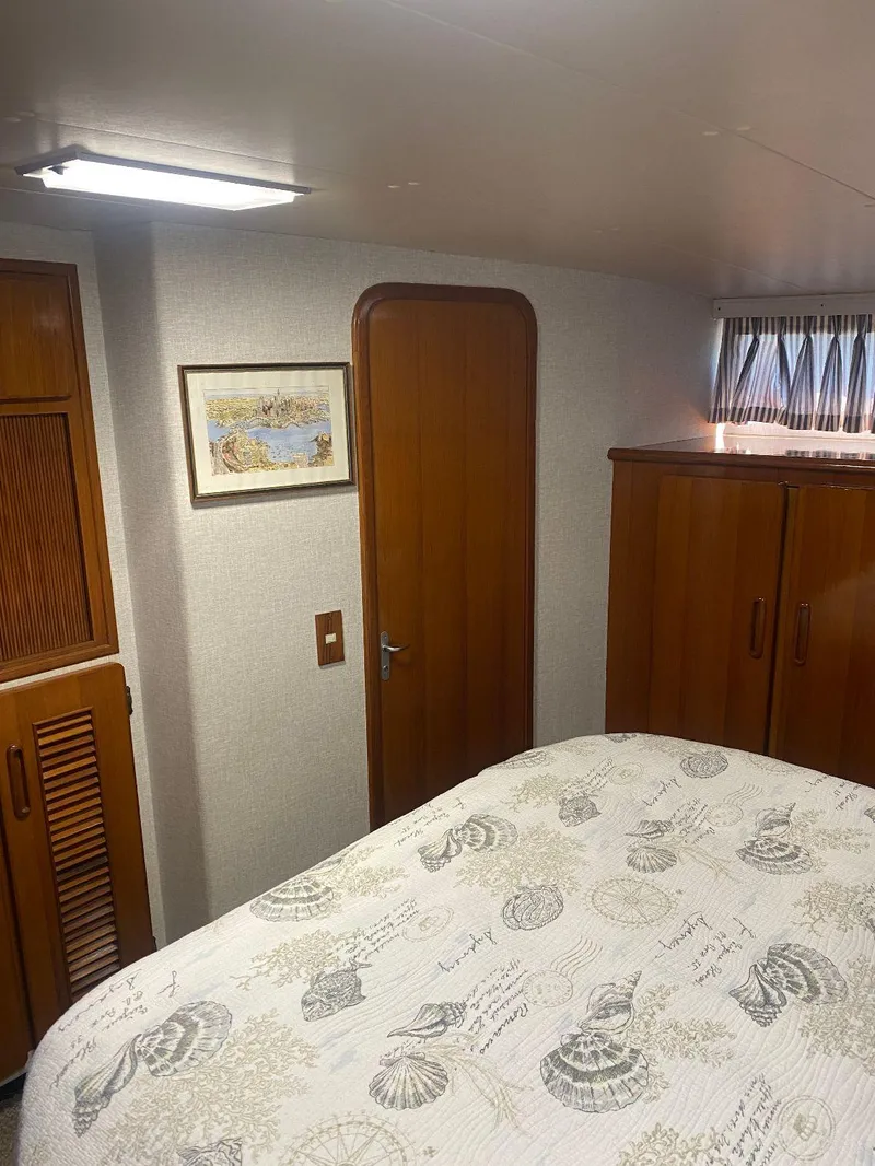 Slide: The Image of 1990 Jefferson 42 Viscount Sundeck bedroom with wooden cabinets and nautical-themed bedding. - 46
