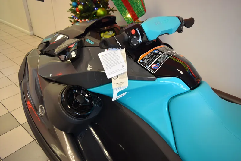 Slide: The Image of 2024 Sea-Doo GTR 230 jet ski in showroom, featuring sleek black and blue design. - 5