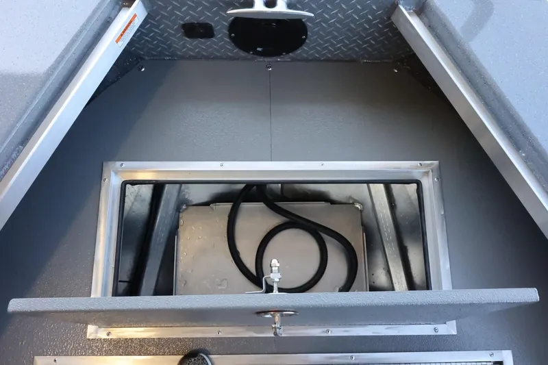 Slide: The Image of 2025 Thunder Jet 209 Rush OT boat storage compartment with diamond plate flooring. - 20