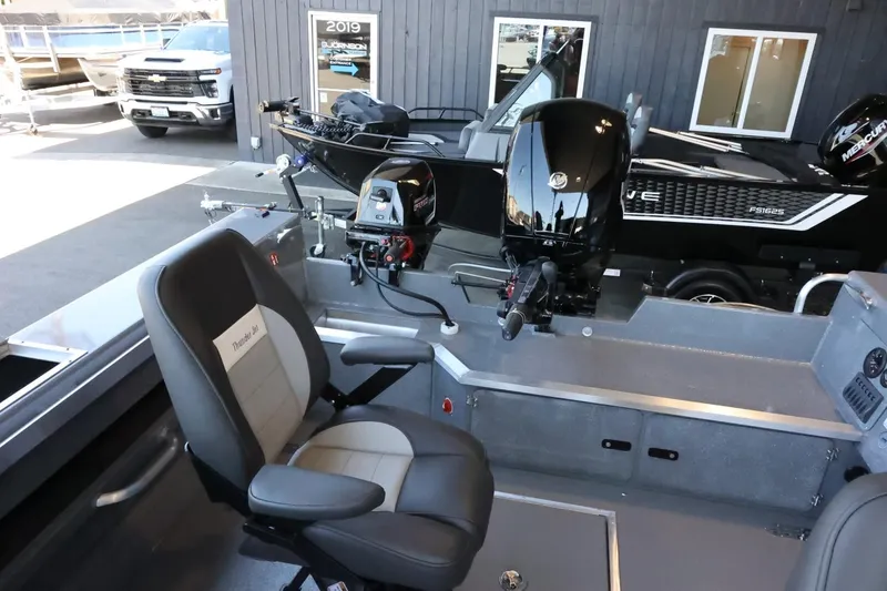 Slide: The Image of 2025 Thunder Jet 209 Rush OT boat interior with seating and motor, displayed outdoors. - 32