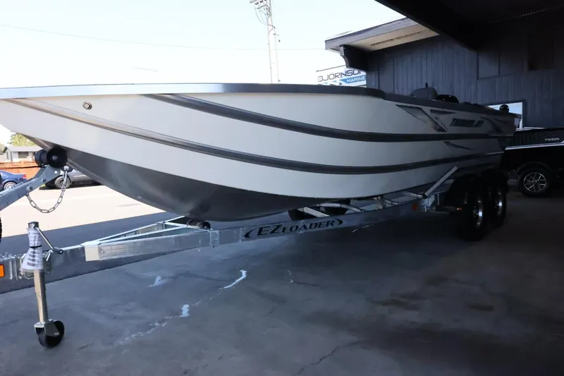 Slide: The Image of 2025 Thunder Jet 209 Rush OT boat on EZ Loader trailer in a shaded area. - 5