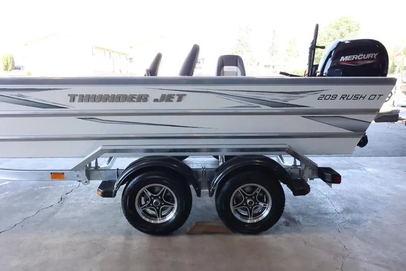 Slide: The Image of 2025 Thunder Jet 209 Rush OT boat on trailer with Mercury engine, side view. - 6