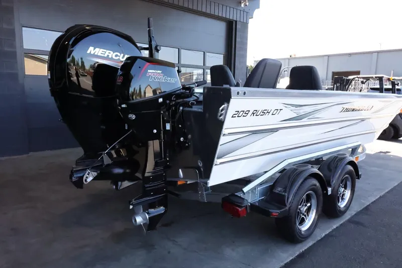 Slide: The Image of 2025 Thunder Jet 209 Rush OT boat with Mercury outboard motor, parked on a trailer. - 9