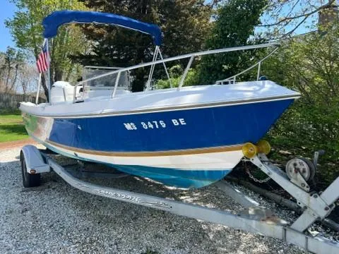 Slide: The Image of 2001 Aquasport 200 Osprey boat on trailer, blue hull, parked outdoors. - 0
