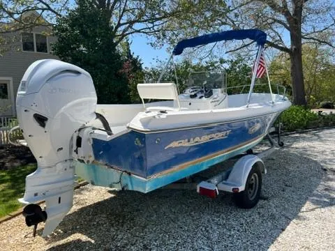 Slide: The Image of 2001 Aquasport 200 Osprey boat on trailer, blue hull, outboard motor, parked outdoors. - 1