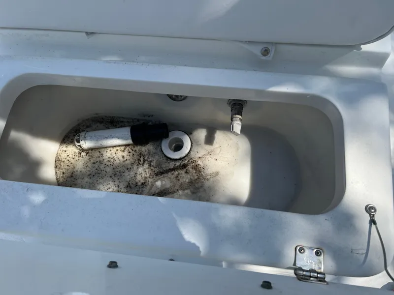 Slide: The Image of Livewell compartment in a 2001 Aquasport 200 Osprey boat, showing plumbing and debris. - 12