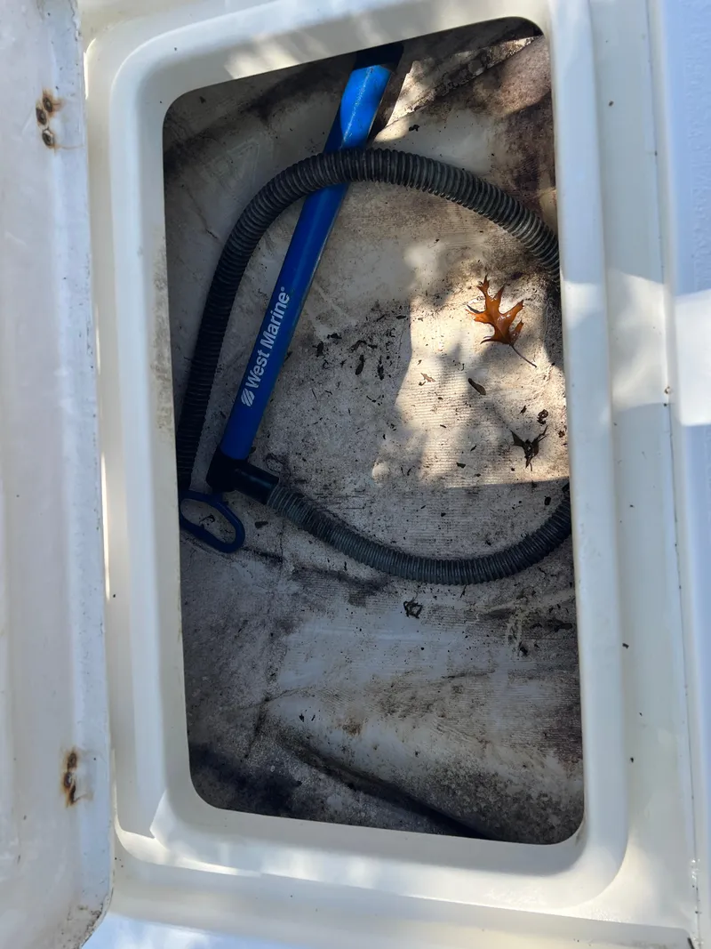 Slide: The Image of Storage compartment of 2001 Aquasport 200 Osprey boat with hose and debris. - 15